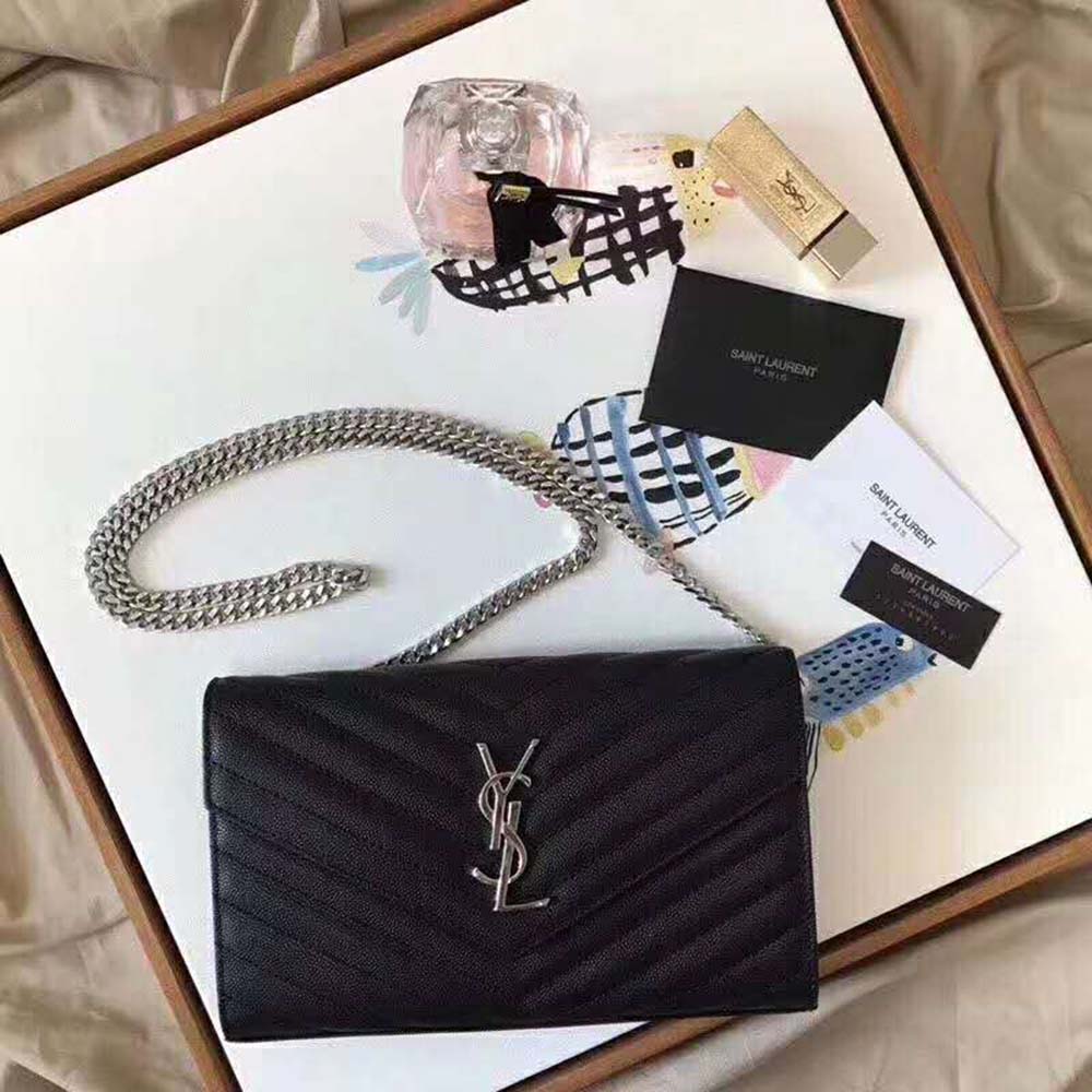 Close-up on silver YSL monogram and chain detail of the wallet