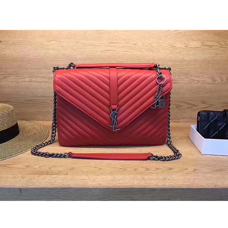 Close-up of gold YSL logo on red matelassé leather bag