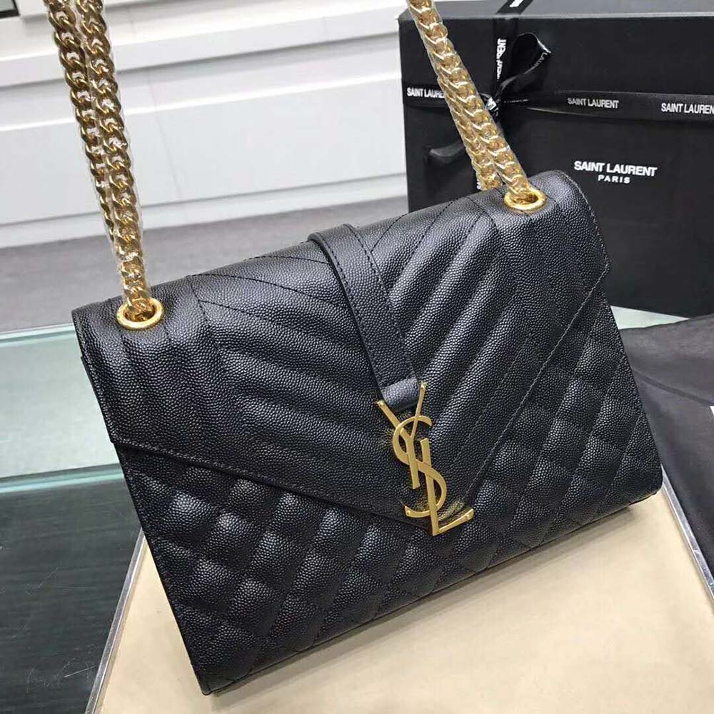 Close-up of gold YSL logo and quilted mixed grain leather detail
