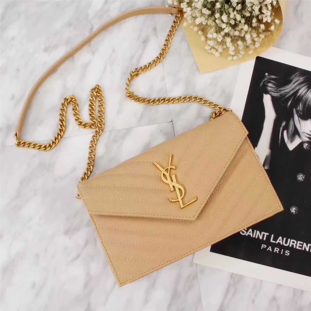 Close-up on gold YSL logo and chain hardware on wallet