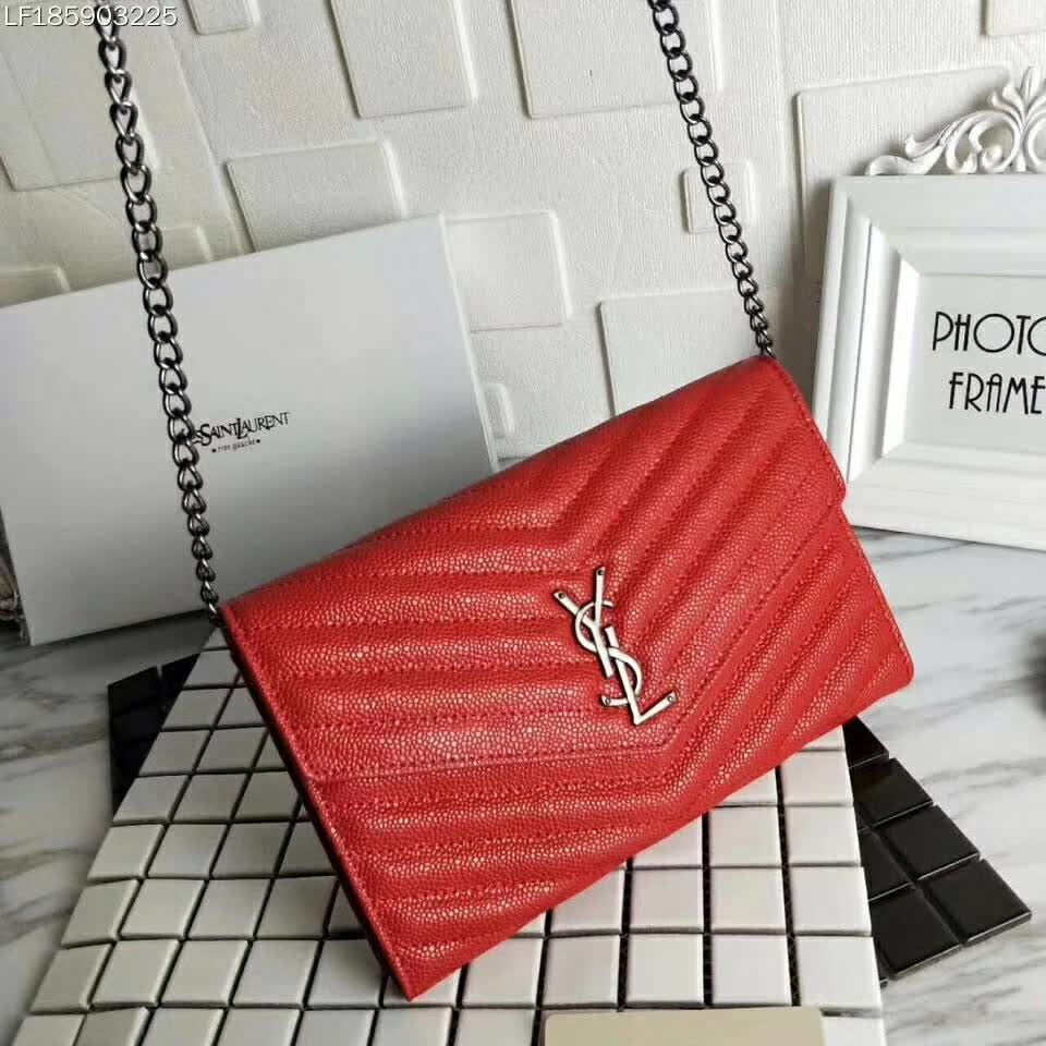 Close-up on silver YSL monogram hardware on red leather wallet