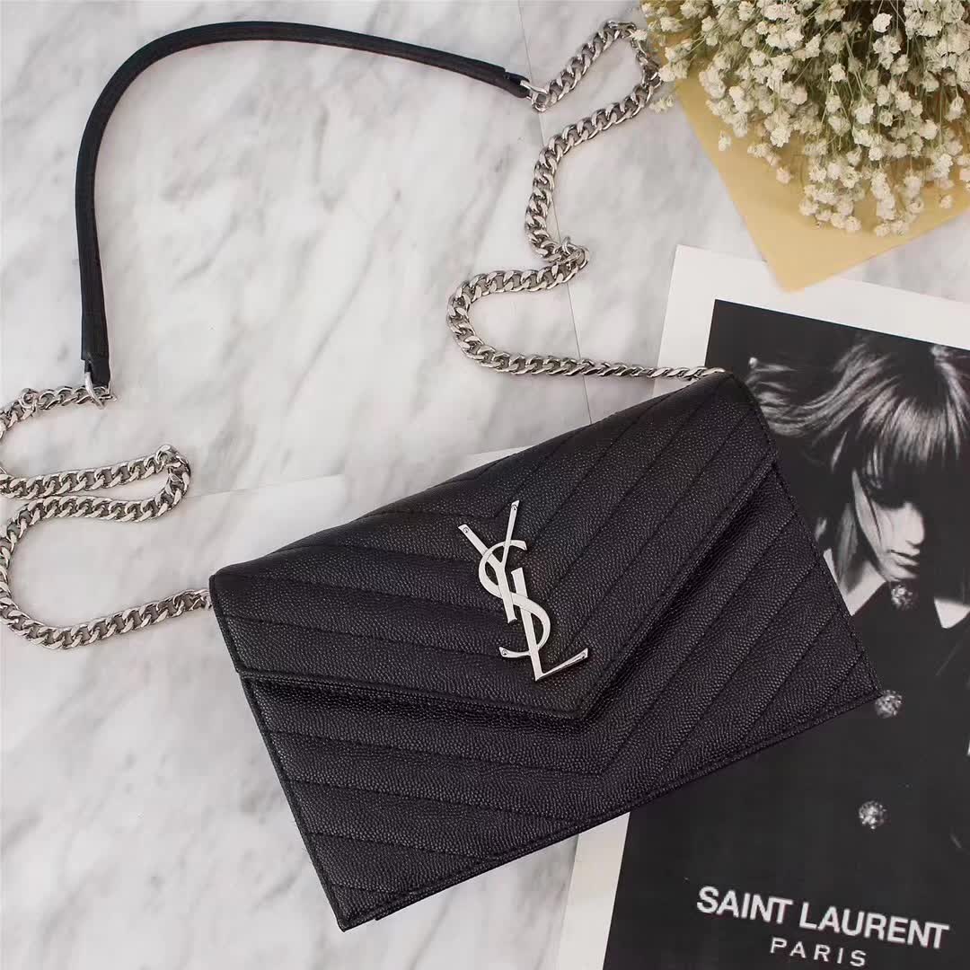 Close-up of silver YSL monogram on black leather wallet