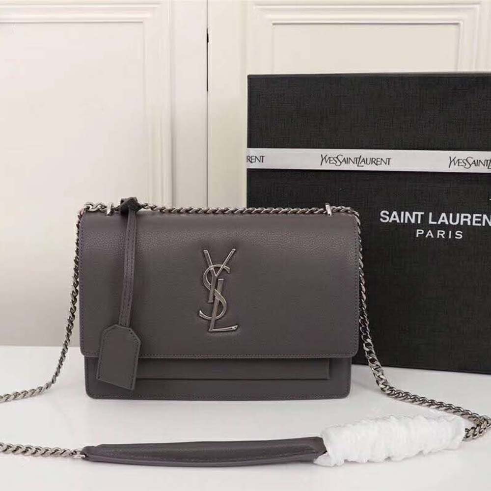 Close-up of gold YSL logo hardware on Medium Sunset Bag grey leather