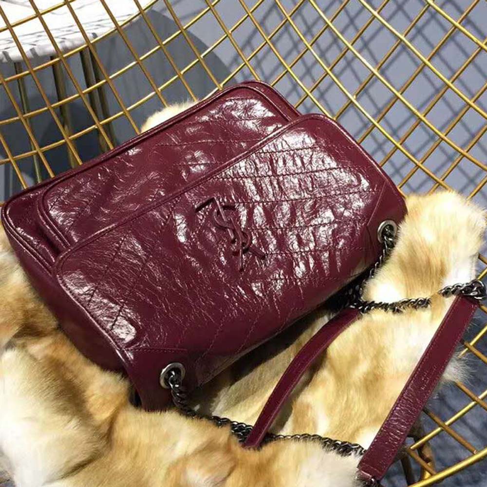 Close-up of antique gold YSL hardware on vintage leather bag