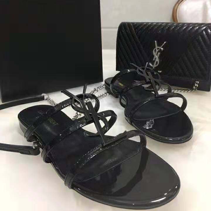 Close-up of gold YSL logo hardware on Black Cassandra Open Sandals