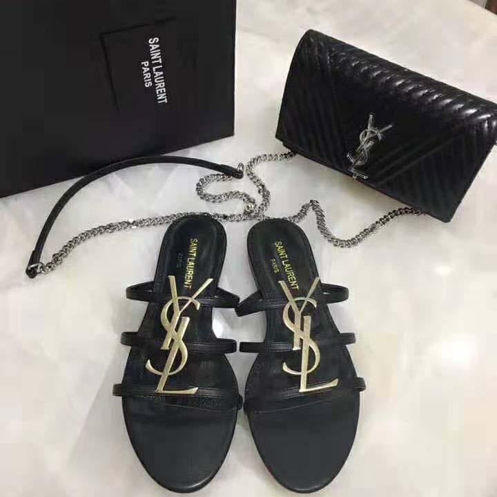 Close-up of YSL signature hardware on black smooth leather sandals