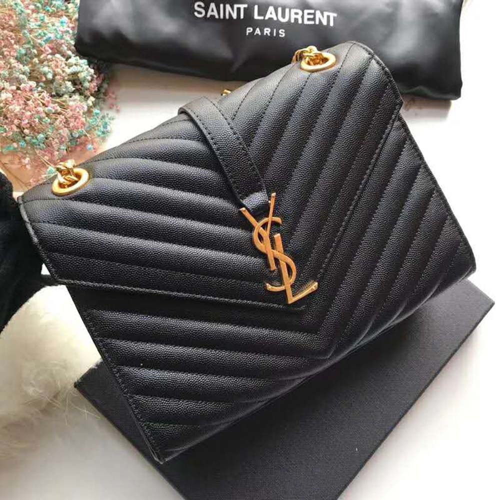 Close-up of gold YSL hardware on black grain de poudre leather bag