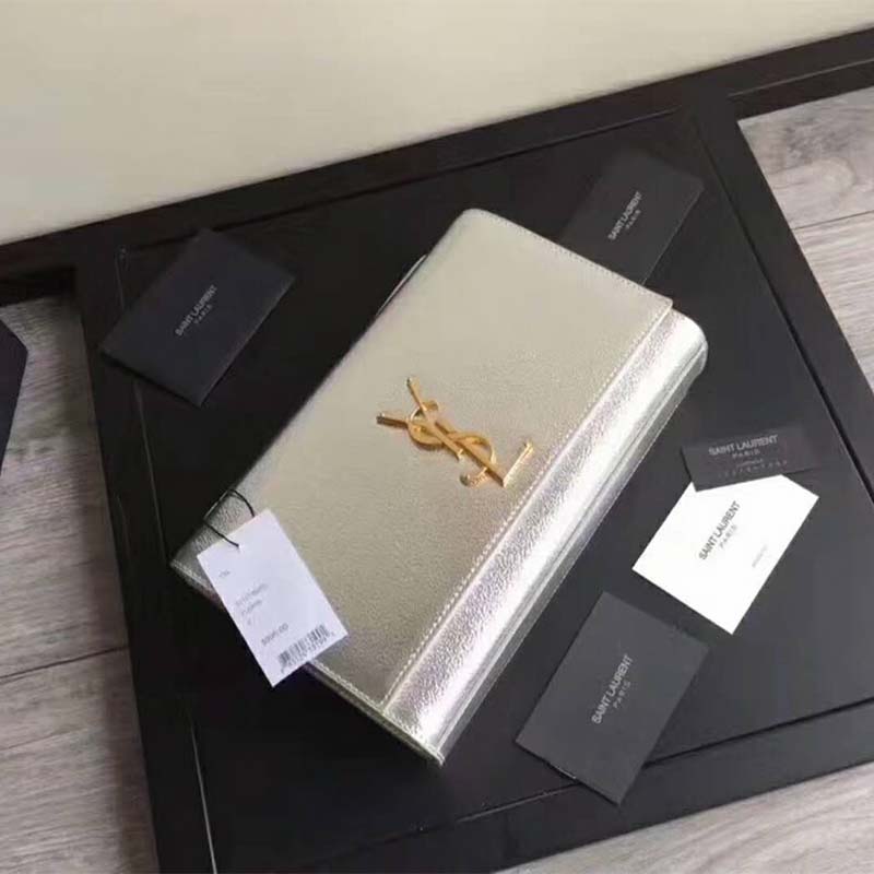Close-up of polished YSL logo and silver grained leather texture