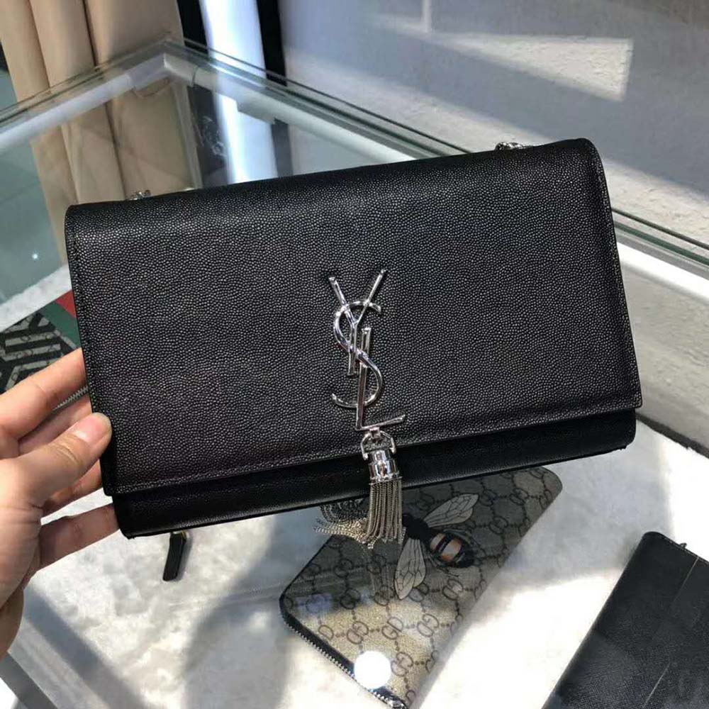 Close-up of gold YSL logo and tassel detail on Saint Laurent Kate bag