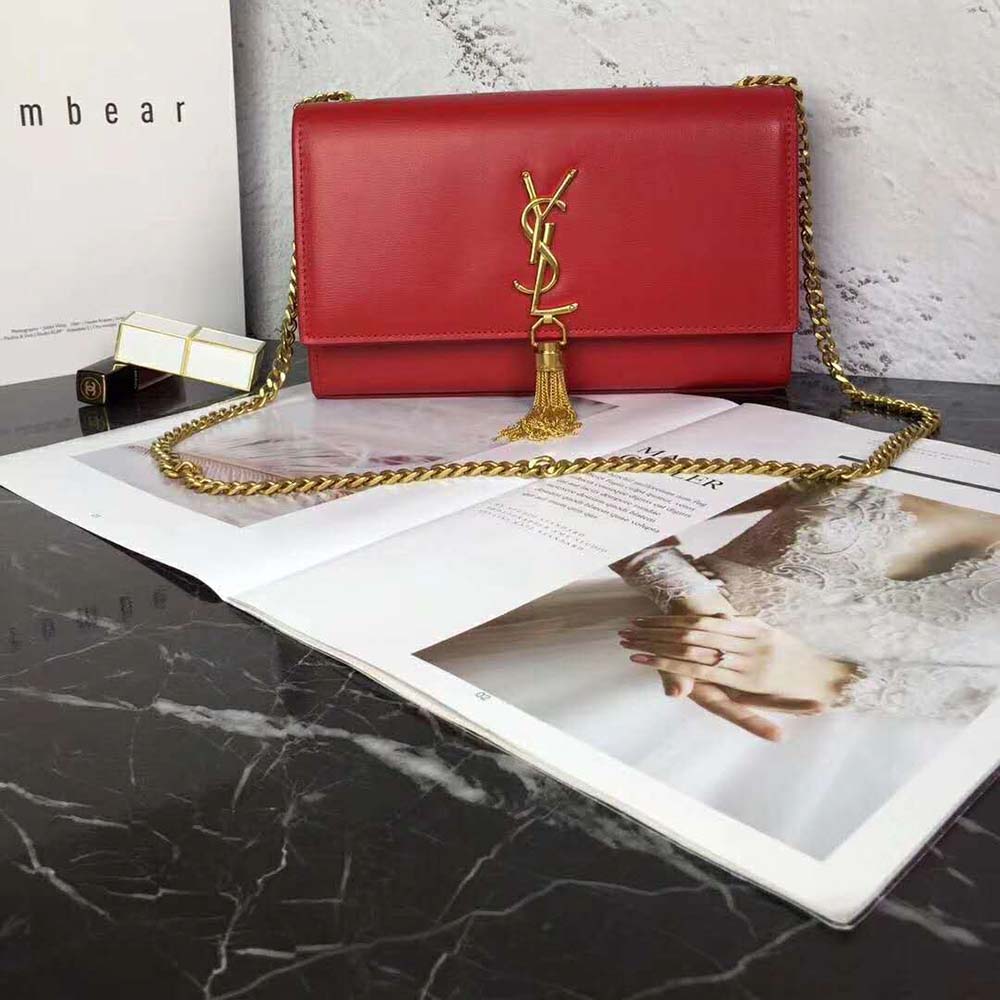 Close-up of gold YSL logo and tassel detail on Saint Laurent bag