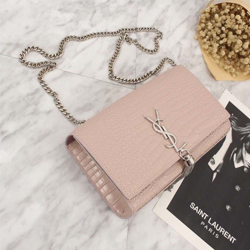 Close-up of pink embossed crocodile pattern and gold YSL logo detail