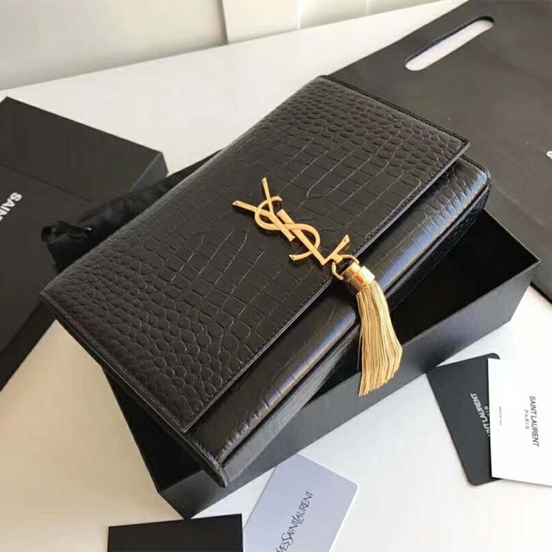 Close-up of gold tassel and embossed crocodile leather on Saint Laurent YSL bag