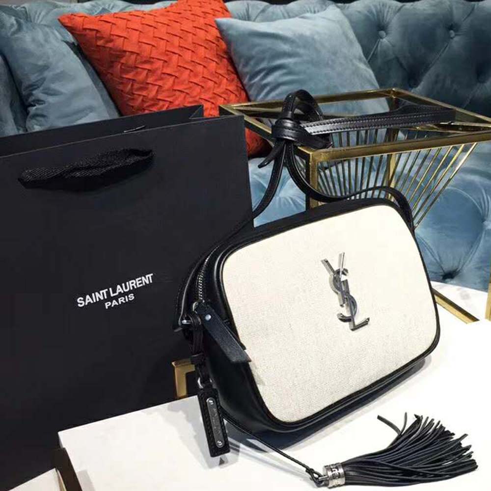 Close-up of gold YSL logo hardware on white linen canvas bag