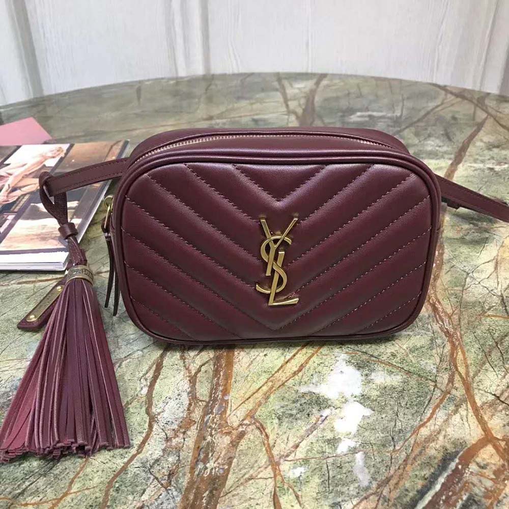 Close-up of gold YSL logo on maroon matelassé leather bag