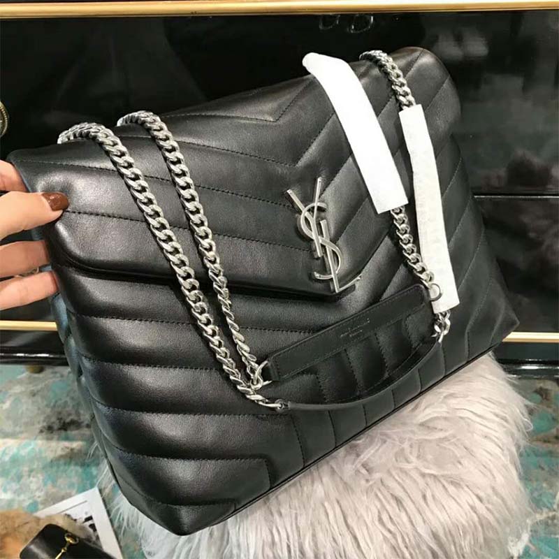 Close-up of silver YSL logo hardware on black matelasse leather bag