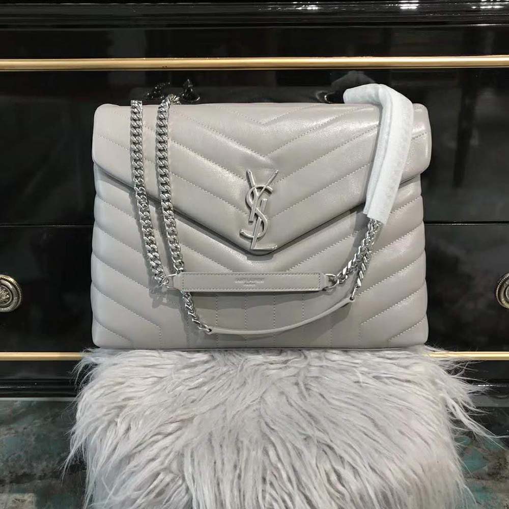 Close-up of white leather quilting and gold YSL emblem on Saint Laurent YSL Loulou