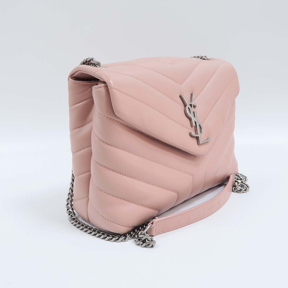Close-up of gold YSL monogram on pink matelassé leather bag