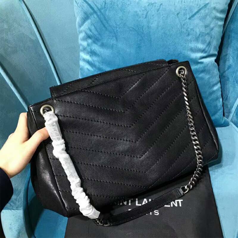 Close-up on gold YSL monogram hardware on Saint Laurent Nolita bag