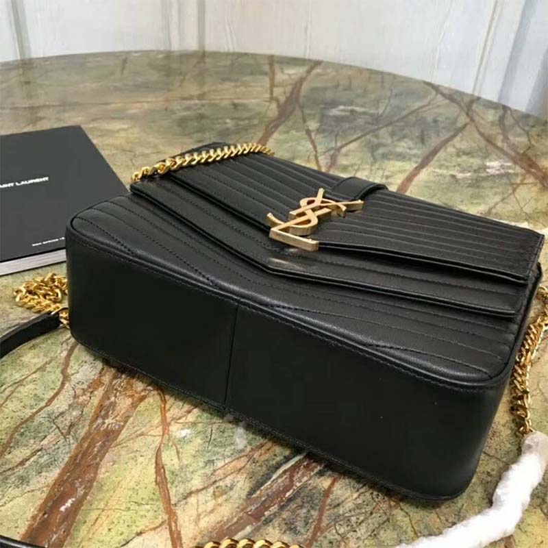 Close-up of gold-tone YSL logo on black quilted lambskin bag