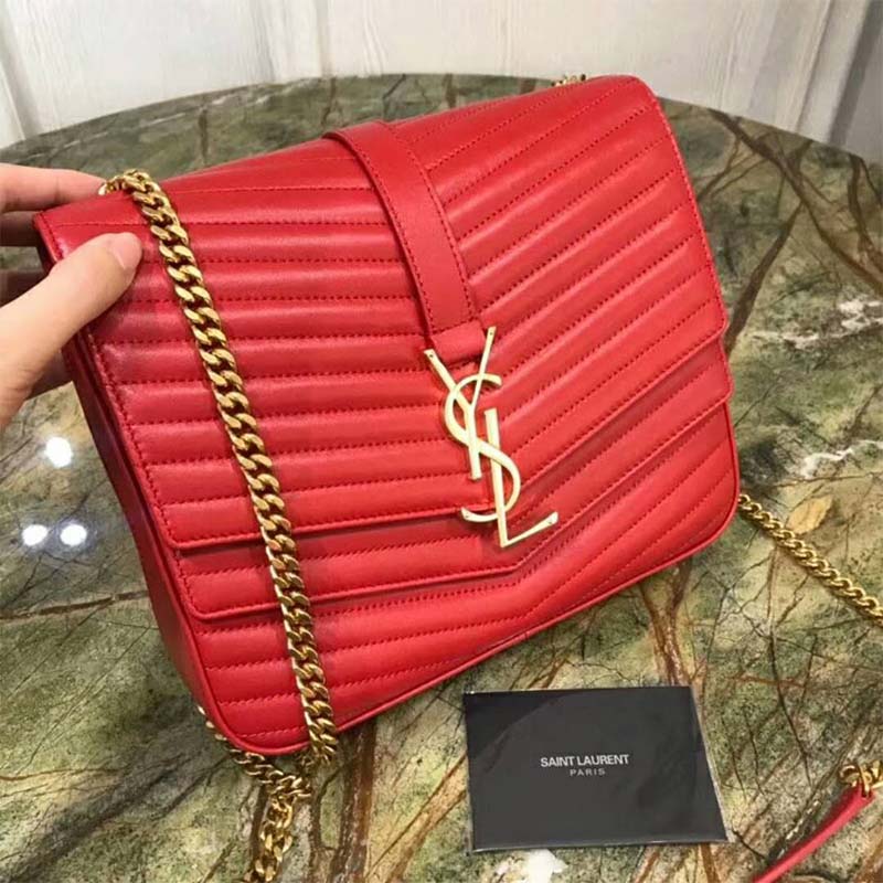 Close-up of gold YSL logo hardware on red lambskin bag
