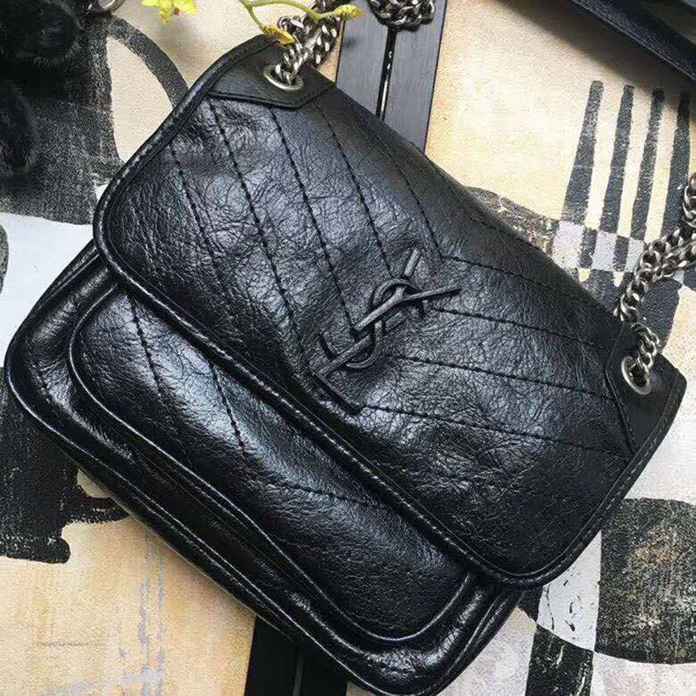 Close-up of gold YSL logo on Niki Baby Crinkled Vintage Bag-Black