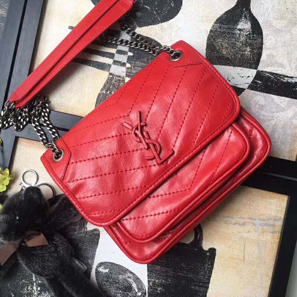 Side angle showing zipper and adjustable strap of Niki Baby Bag red