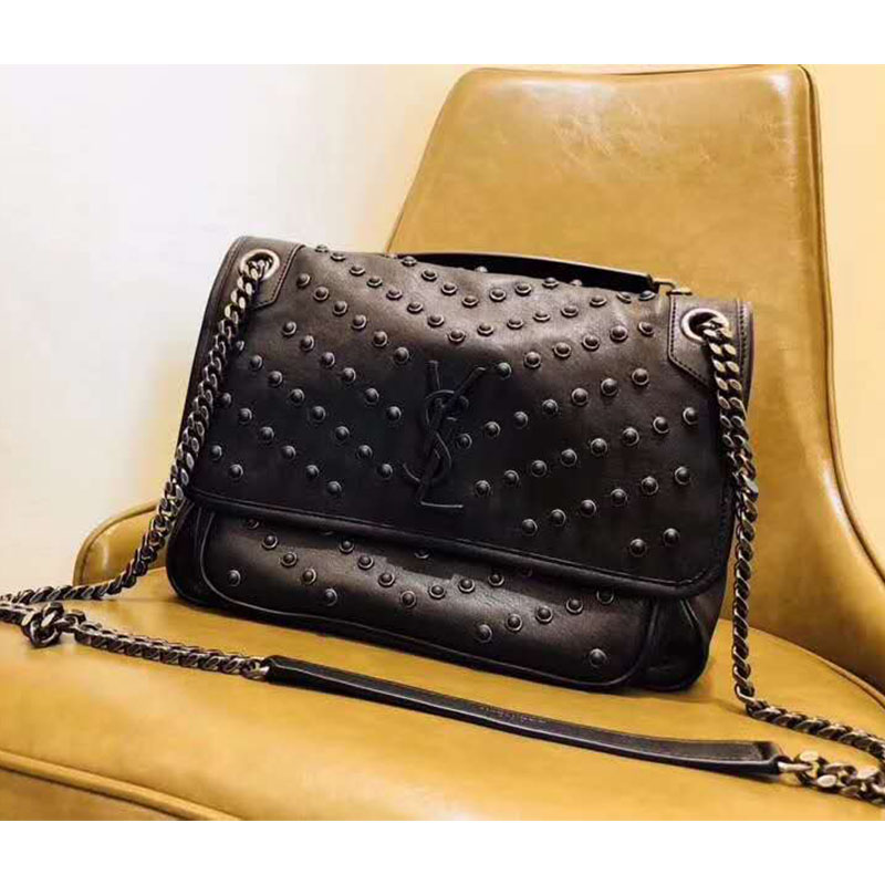 Close-up on gold-tone studs and black vintage leather detailing