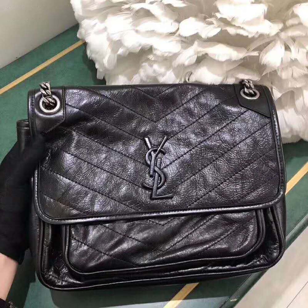 Close-up of gold YSL logo on Saint Laurent YSL Women Niki Medium vintage leather