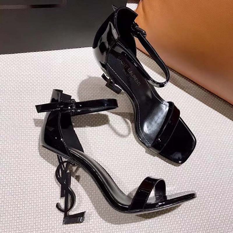 Close-up on gold-tone YSL logo hardware on Saint Laurent YSL Women Opyum 110 Sandals