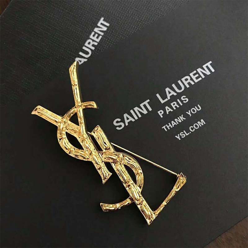 Close-up detail of gold crocodile texture on Saint Laurent YSL brooch