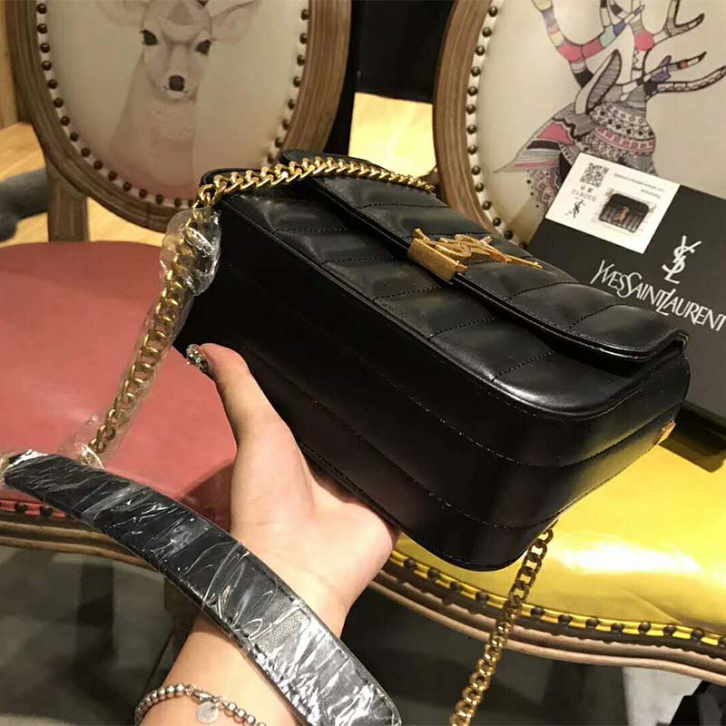 Close-up of gold YSL logo hardware on shoulder bag