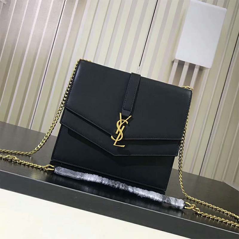 Close-up of YSL gold monogram on smooth leather bag