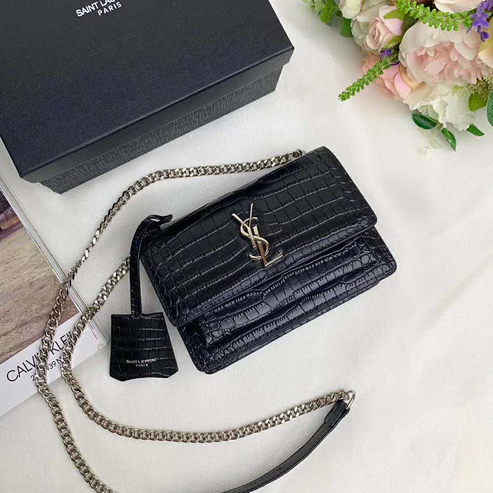 Close-up on gold YSL logo hardware on Saint Laurent YSL Women Sunset Medium bag