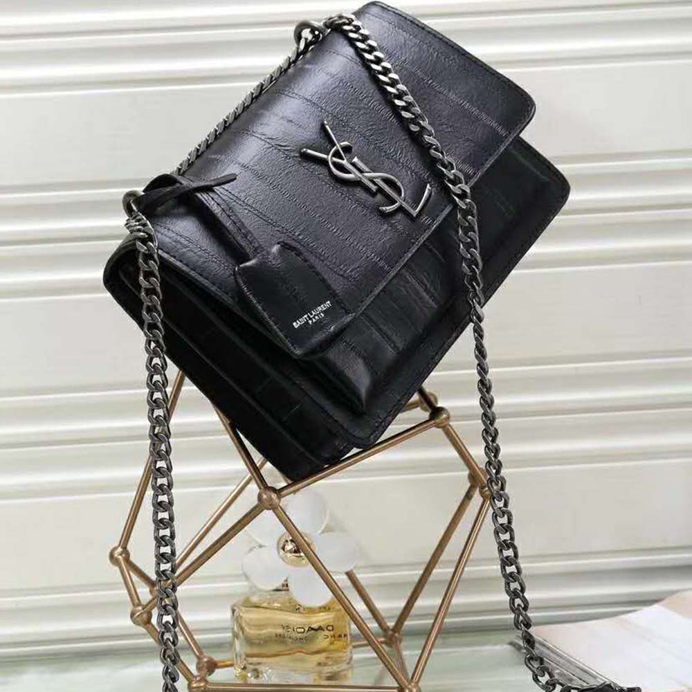 Close-up of gold-tone YSL clasp on Sunset Medium Eel-Black bag