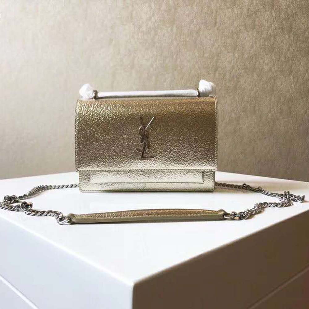 Close-up on gold YSL logo hardware of Sunset Small metallic bag