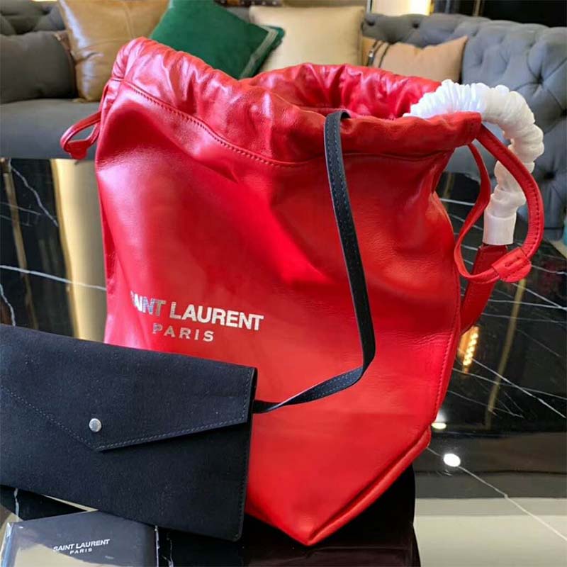 Close-up of gold YSL hardware on red leather drawstring bag