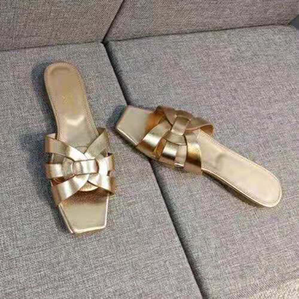 Close-up of signature YSL gold-tone hardware on Tribute Flat Sandals