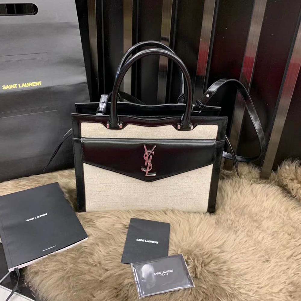 Close-up detail of gold YSL hardware on Uptown Large Tote white canvas