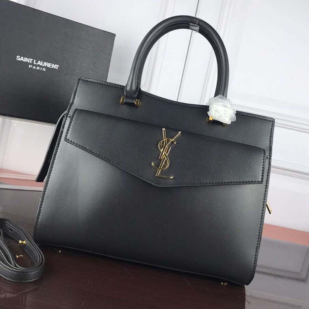 Close-up of gold YSL hardware on Uptown Medium Tote in shiny black leather