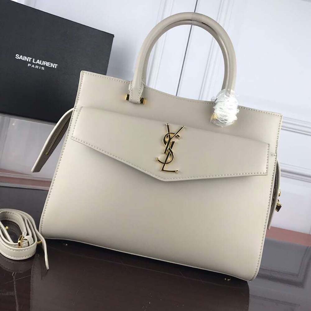 Close-up on gold YSL hardware and smooth white leather details