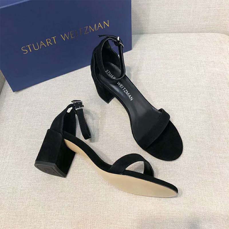 Close-up of polished buckle on Stuart Weitzman The Simple Sandal in black
