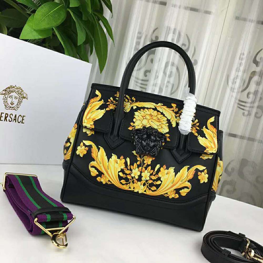 Side angle showing smooth black leather and structured silhouette of Versace bag