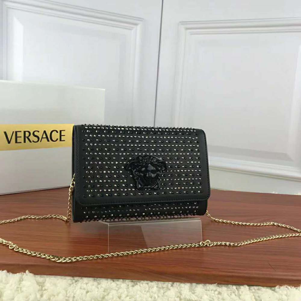 Close-up of gold Medusa hardware on Versace Women Crystal Palazzo Evening Bag-Black
