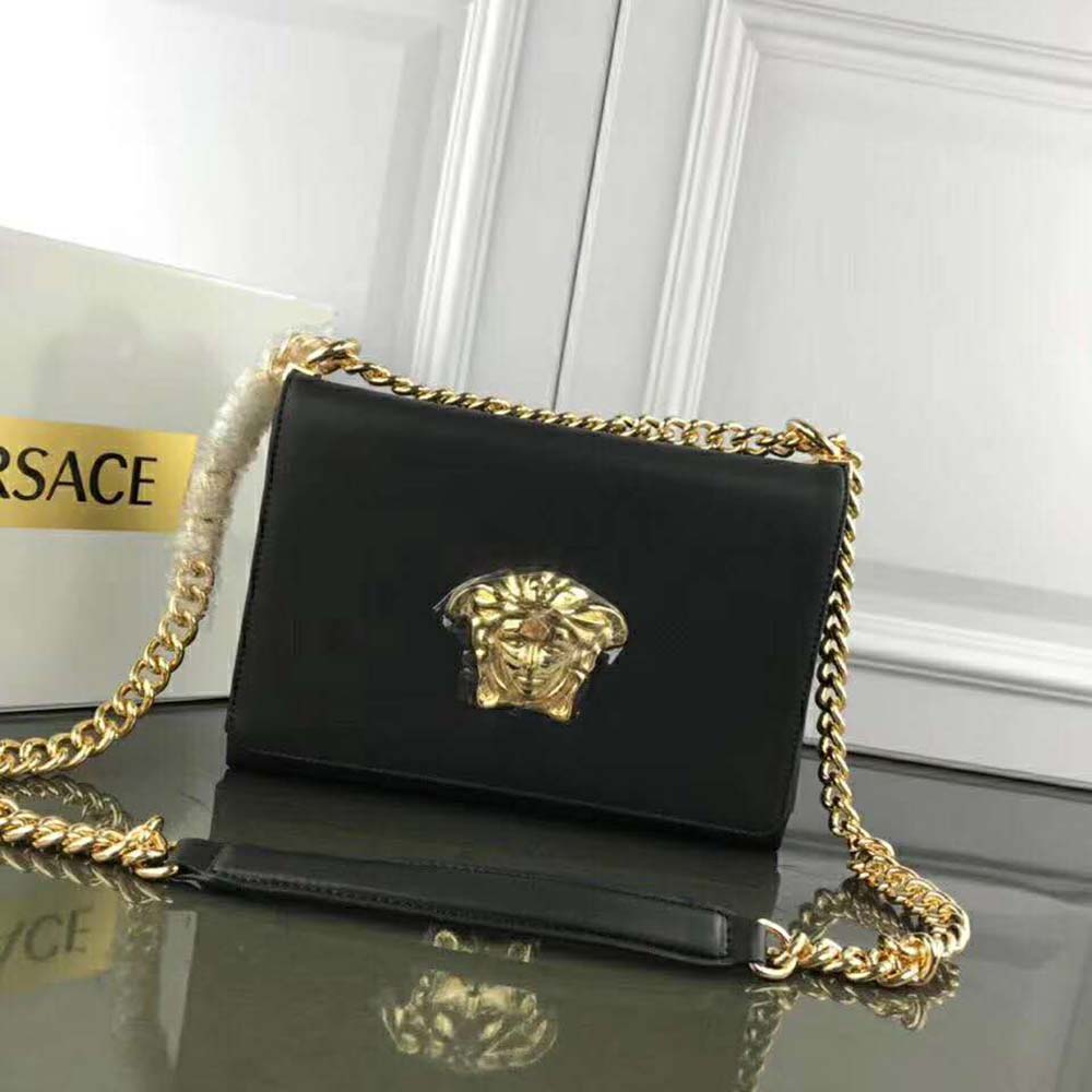 Close-up of gold Medusa head hardware on Versace Women Medusa Head Evening Clutch Bag-Black