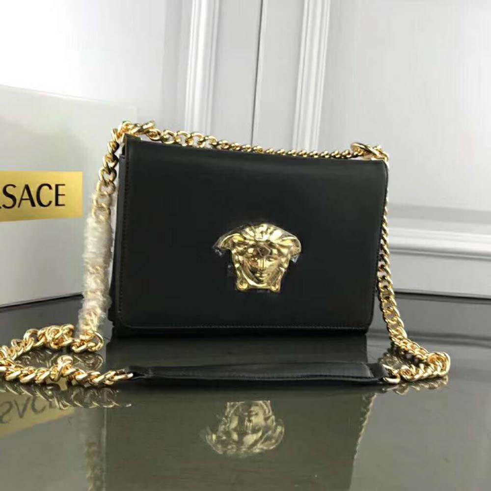 Side angle showing sleek black leather and magnetic closure of Versace Women Medusa Head Evening Clutch Bag-Black