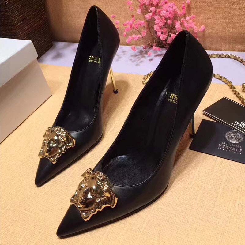 Close-up of gold Medusa hardware on Versace Palazzo Pumps black leather
