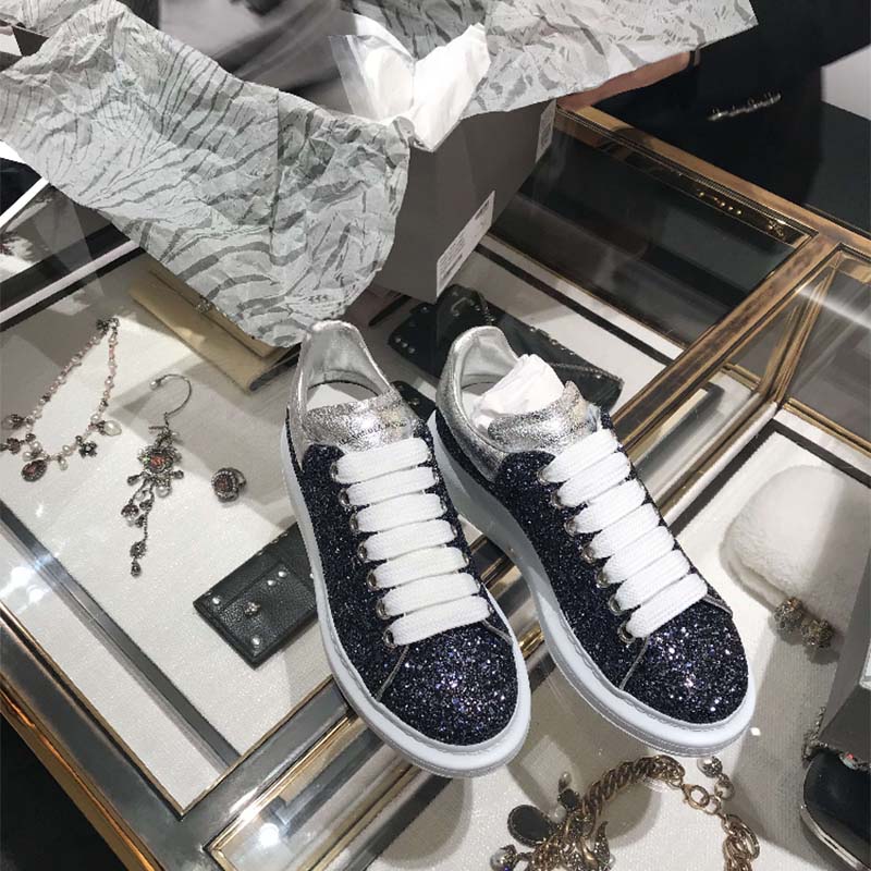 Close-up of silver glitter leather and branded heel tab on sneaker