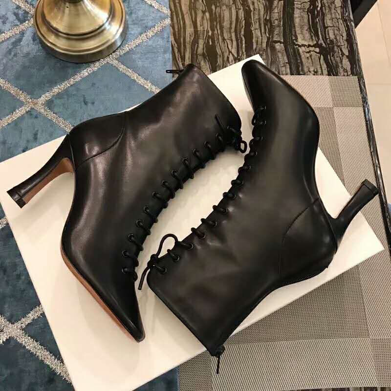 Rear angle showing heel and leather texture on black Celine ankle bootie