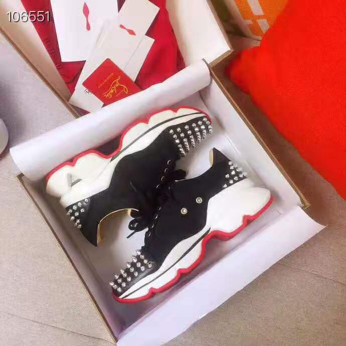Close-up on black leather and signature red sole of Christian Louboutin sneakers