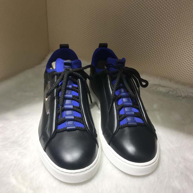 Close-up of black leather and Fendi logo hardware on sneakers